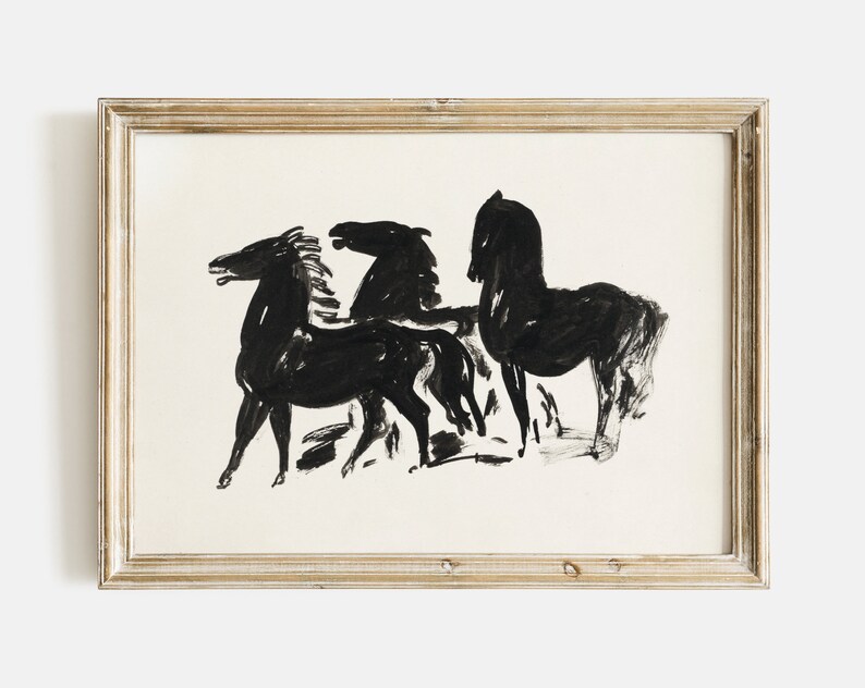 May include: Black and white ink drawing of three horses in a minimalist style. The horses are depicted in a simple, abstract manner, with their bodies and heads outlined in black ink. The drawing is framed in a light wood frame.