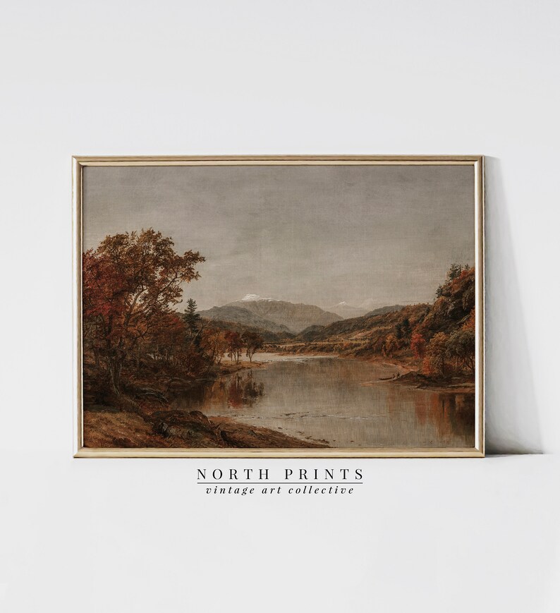 May include: A vintage painting of a river scene with trees and mountains in the background. The sky is a light gray, and the water is a calm blue. The trees are a mix of green and brown, and the mountains are a dark gray. The painting is framed in a simple wooden frame.