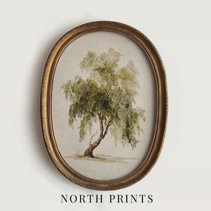 Puede incluir: Una impresión enmarcada ovalada con una acuarela de un árbol con follaje verde y un tronco curvo. El marco es de color dorado. El texto "NORTH PRINTS" está en la parte inferior de la imagen.