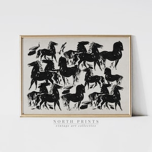 May include: Black and white abstract print of a group of horses running. The print is framed in a light wood frame and has the text "NORTH PRINTS vintage art collective" at the bottom.