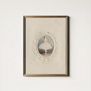 May include: A framed vintage print of a ballerina in a white tutu, standing on a stage. The print is surrounded by a decorative white frame with a floral design.