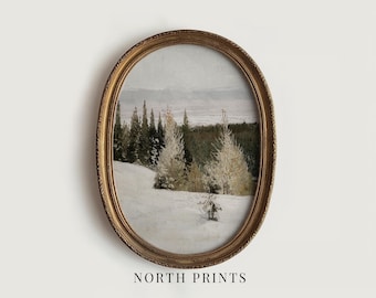 May include: An oval-shaped, ornate gold frame containing a landscape painting of a snow-covered field with evergreen trees and pale, frost-dusted foliage under a muted sky. The text NORTH PRINTS is printed in black below the framed artwork.