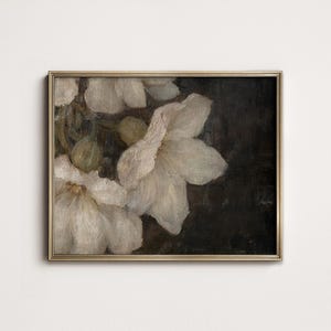 May include: A framed painting of white flowers on a dark background. The flowers are in focus and the background is blurred. The painting is in a gold frame.
