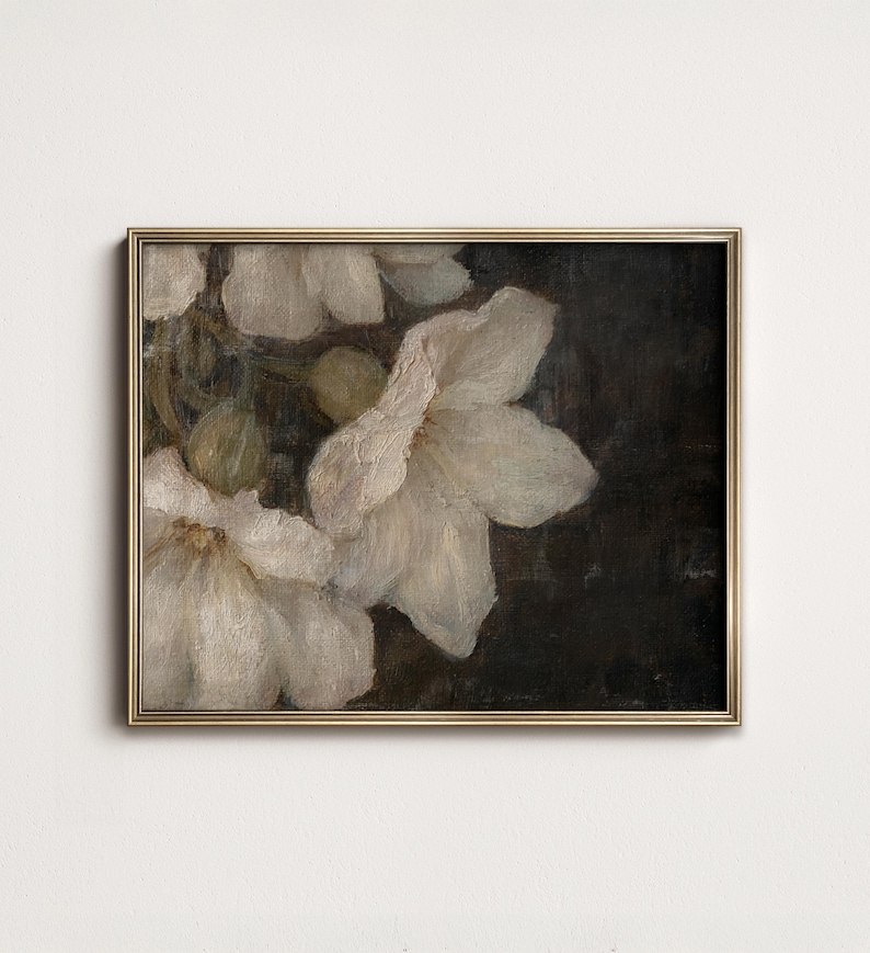 May include: A framed painting of white flowers on a dark background. The flowers are in focus and the background is blurred. The painting is in a gold frame.