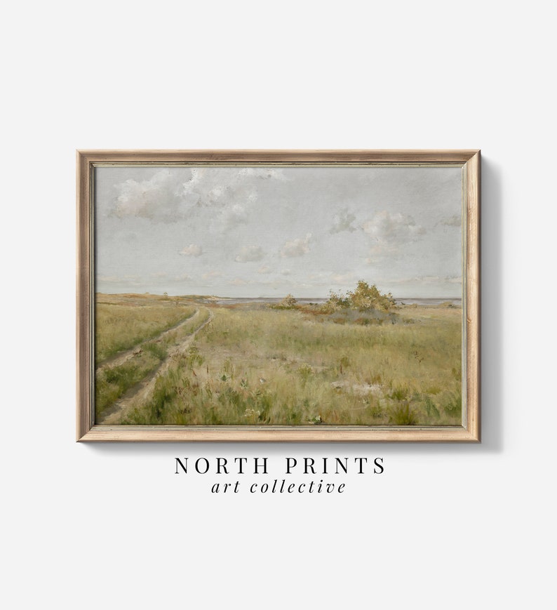 May include: A framed painting of a landscape with a dirt road leading to a body of water. The sky is a light blue with white clouds. The grass is green and the water is a light blue.