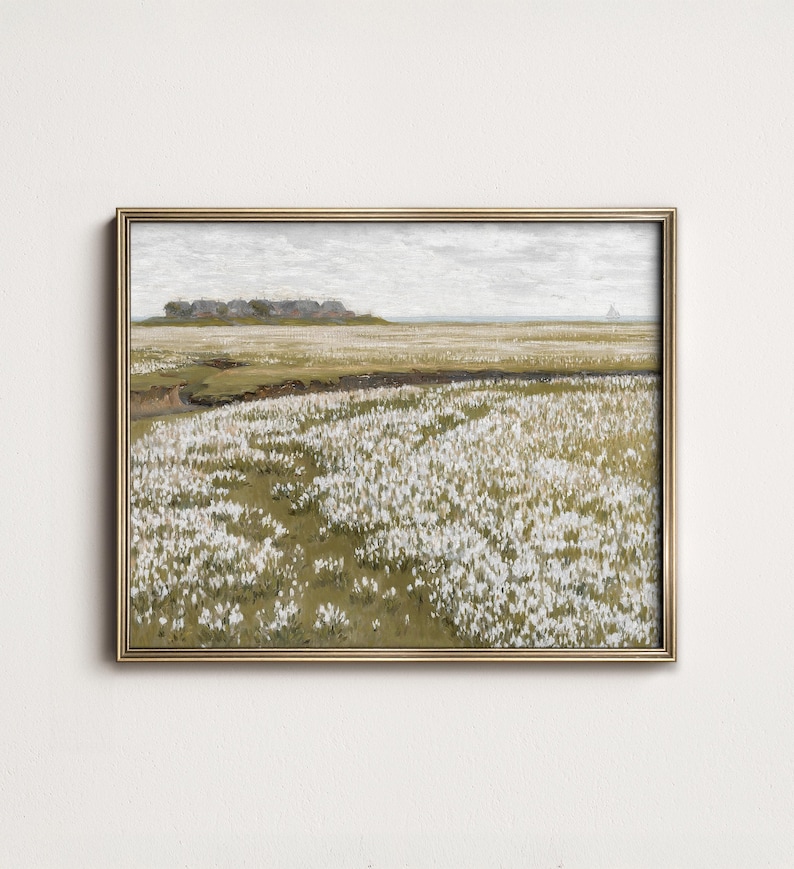 May include: A framed painting depicting a field of white flowers in bloom. The field is set against a backdrop of a cloudy sky and a distant shoreline. The painting is framed in a gold-colored frame.
