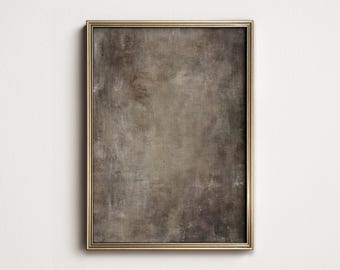 May include: A rectangular framed artwork with a textured, abstract design in shades of brown and gray. The frame is a thin, gold color, and the artwork is mounted on a white wall.