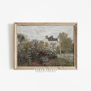 Puede incluir: Una pintura vintage de una casa con un jard&iacute;n en primer plano. La casa es blanca con un techo gris y tiene una peque&ntilde;a ventana en el lateral. El jard&iacute;n est&aacute; lleno de arbustos verdes y flores rojas. El cielo es gris y nublado. La pintura est&aacute; enmarcada en un marco de madera claro.