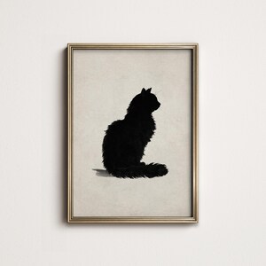Peut inclure: Impression artistique encadr&eacute;e repr&eacute;sentant une silhouette noire de chat assis. Le chat, avec une fourrure touffue et une longue queue, est pr&eacute;sent&eacute; de profil. L'&oelig;uvre est encadr&eacute;e dans un cadre dor&eacute;, sur fond neutre. Parfait pour la d&eacute;coration int&eacute;rieure.