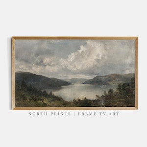 May include: A framed landscape painting featuring a serene lake scene under a cloudy sky. The artwork showcases rolling hills and lush greenery, with the text "NORTH PRINTS | FRAME TV ART" at the bottom.
