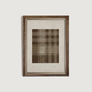 May include: Framed print featuring a brown and tan plaid pattern. The artwork is displayed within a wooden frame, adding a touch of rustic elegance. The plaid design is a classic pattern, suitable for various interior design styles.