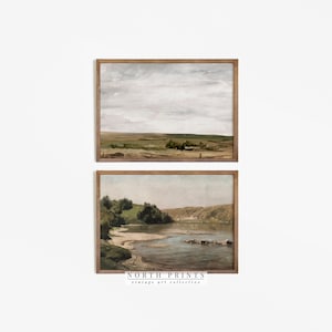 May include: Two framed landscape paintings. The top painting shows a field with a cloudy sky. The bottom painting shows a river with trees and a rocky shore.