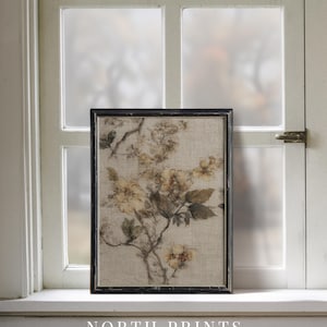 Op de afbeelding: Een ingelijste bloemenprint met een tak met gele bloemen en groene bladeren. Het kunstwerk staat tegen een neutrale achtergrond en is ingelijst in een zwart, rechthoekig frame. De tekst "NORTH PRINTS art collective" staat onderaan.