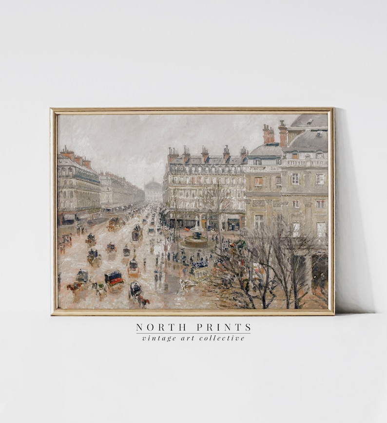 May include: A framed vintage art print showing a wet street scene with horse-drawn carriages and people. The artwork uses muted tones of grey, beige, and brown, with buildings along the street. The print is labelled "NORTH PRINTS vintage art collective."