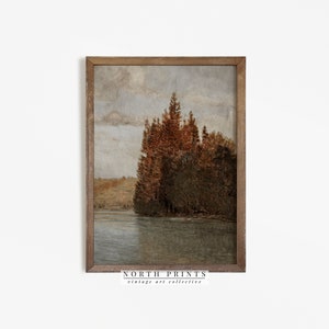 May include: A vintage landscape painting of a lake with trees on the shore. The trees are a mix of green and brown, and the lake is a calm blue. The sky is a light blue with some clouds. The painting is framed in a brown wood frame.