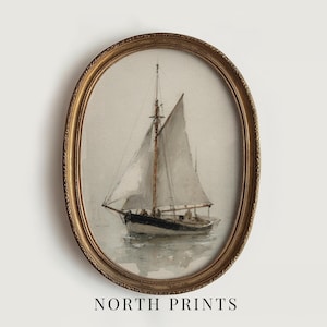 May include: An oval-shaped, ornate gold frame containing a watercolor painting of a sailboat on calm water. The sailboat features white sails and a dark hull, depicted in muted tones. The text "NORTH PRINTS" is printed in black below the frame.