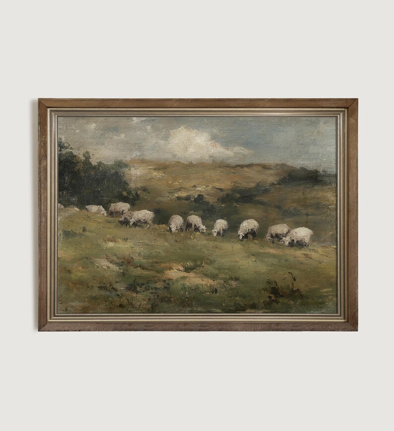 K&ouml;nnte beinhalten: Gerahmtes Gem&auml;lde im antiken Stil, das Schafe zeigt, die auf einem grasbewachsenen H&uuml;gel grasen. Das Kunstwerk verwendet eine ged&auml;mpfte Farbpalette aus Gr&uuml;n-, Braun- und Blaut&ouml;nen, mit einem bew&ouml;lkten Himmel und einem Holzrahmen.