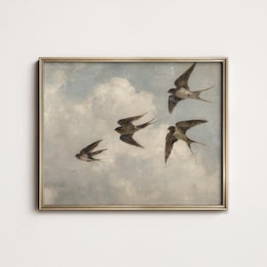 May include: A framed painting shows four swallows soaring through a cloudy sky. The birds are dark brown with white details, and the frame is gold. The artwork conveys a feeling of freedom and motion.