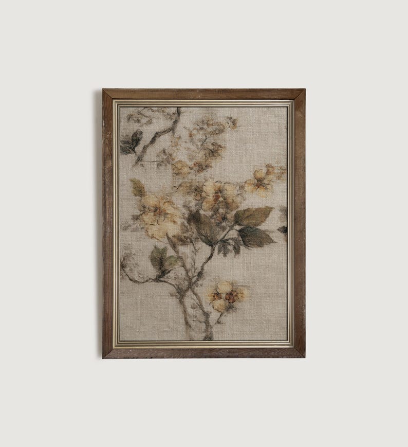Op de afbeelding: Een ingelijste bloemenprint met een botanische illustratie van gele bloemen en groene bladeren op een beige achtergrond. Het kunstwerk is ingesloten in een bruine houten lijst, wat een vintage esthetiek cre&euml;ert. De print heeft een getextureerd uiterlijk.