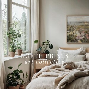 Peut inclure: Une chambre &agrave; coucher avec un lit recouvert d'une couette en lin blanc et d'oreillers. Il y a une table de chevet en bois &agrave; c&ocirc;t&eacute; du lit avec une plante dessus. Un tableau encadr&eacute; repr&eacute;sentant un paysage avec des fleurs est accroch&eacute; au mur au-dessus de la table de chevet. Le texte "NORTH PRINTS art collective" est visible sur l'image.