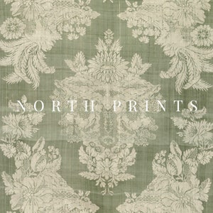 May include: A close-up of a green fabric with a white floral pattern. The fabric has a textured surface and a subtle sheen. The text "NORTH PRINTS" is printed in white on the fabric.