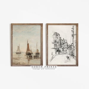 May include: Two framed vintage art prints. The left print is a watercolor of sailboats on the water with a light blue sky. The right print is a pencil sketch of a street scene. The frames are a light brown color. The text "NORTH PRINTS vintage art collective" is at the bottom.