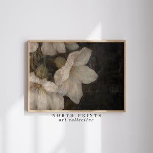 May include: A vintage-style painting of white flowers with a dark background. The flowers are painted in a realistic style with soft, delicate details. The painting is framed in a simple wooden frame.