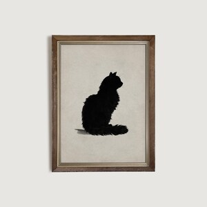 Peut inclure: Impression encadr&eacute;e d'une silhouette noire de chat assis, au pelage touffu, sur fond neutre. Le cadre est en bois de couleur chaude et naturelle.
