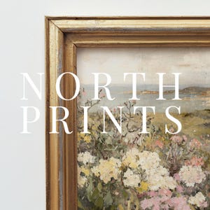 Peut inclure: Une peinture encadr&eacute;e d'un paysage c&ocirc;tier avec un champ de fleurs au premier plan. La peinture est dans un cadre dor&eacute; avec un passe-partout blanc. Le texte "NORTH PRINTS" est superpos&eacute; &agrave; l'image.