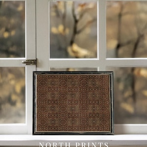 May include: A framed print with a dark brown and beige pattern, positioned in front of a window. The black frame surrounds a repeating floral design. The text "NORTH PRINTS art collective" is visible at the bottom.
