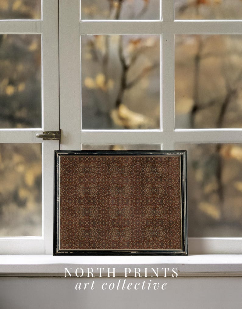May include: A framed print with a dark brown and beige pattern, positioned in front of a window. The black frame surrounds a repeating floral design. The text "NORTH PRINTS art collective" is visible at the bottom.