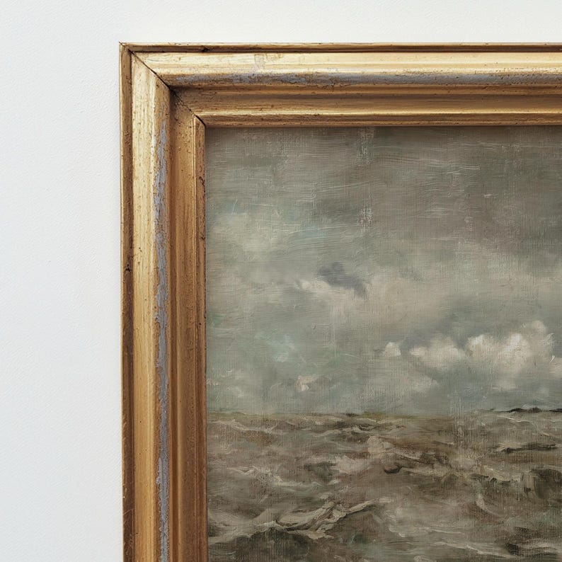 May include: A framed seascape painting with a stormy sea and a cloudy sky. The painting is in a gold frame.