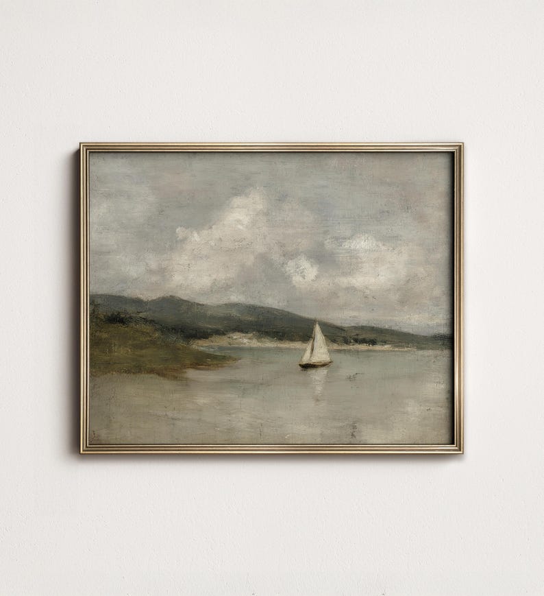 K&ouml;nnte beinhalten: Gerahmtes Vintage-Landschaftsgem&auml;lde. Das Kunstwerk zeigt ein Segelboot auf einem ruhigen Gew&auml;sser, mit einer Kulisse aus sanften H&uuml;geln und einem bew&ouml;lkten Himmel. Die Farbpalette ist ged&auml;mpft, mit Graut&ouml;nen, Gr&uuml;n und Beige.