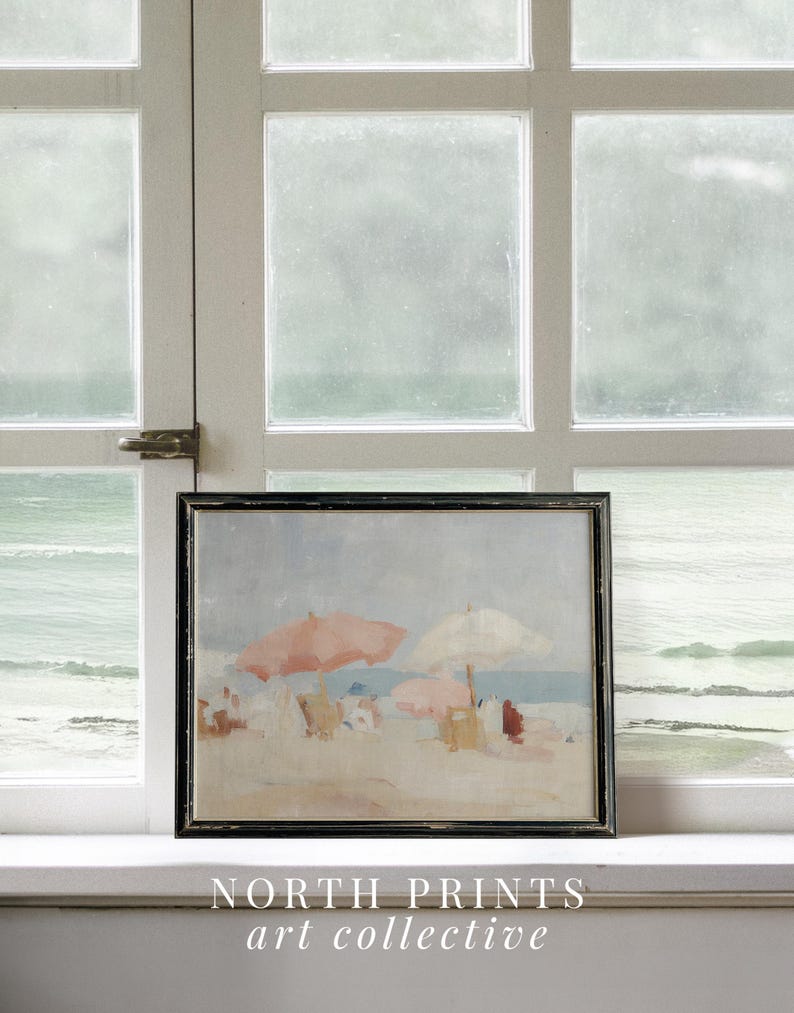 Puede incluir: Pintura enmarcada de una escena de playa con marco negro. La obra representa una playa arenosa con gente, sombrillas y el mar al fondo. La pintura tiene una paleta de colores suaves y apagados con sombrillas rosas y blancas. El texto "NORTH PRINTS art collective" est&aacute; en la parte inferior.