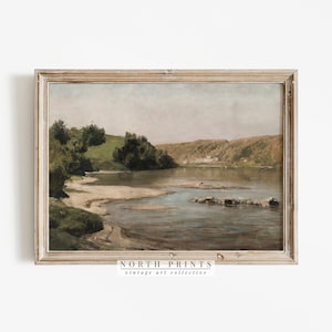Puede incluir: Una pintura vintage de una escena de r&iacute;o con colinas verdes y &aacute;rboles en el fondo. El r&iacute;o est&aacute; tranquilo y el agua es de color azul claro. La pintura est&aacute; enmarcada en un marco de madera claro.