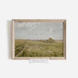May include: A framed painting of a landscape with a dirt road leading to a body of water. The sky is cloudy and the grass is green. The painting is in a light wood frame. "NORTH PRINTS art collective" is printed on a white label below the frame.