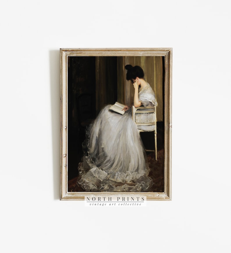 May include: A vintage painting of a woman in a white dress sitting in a chair and reading a book. The painting is framed in a gold frame and has a dark background.