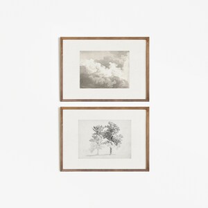 K&ouml;nnte beinhalten: Zwei gerahmte Drucke, einer mit einer Schwarzwei&szlig;zeichnung eines Baumes und der andere mit einem Aquarellbild von Wolken.