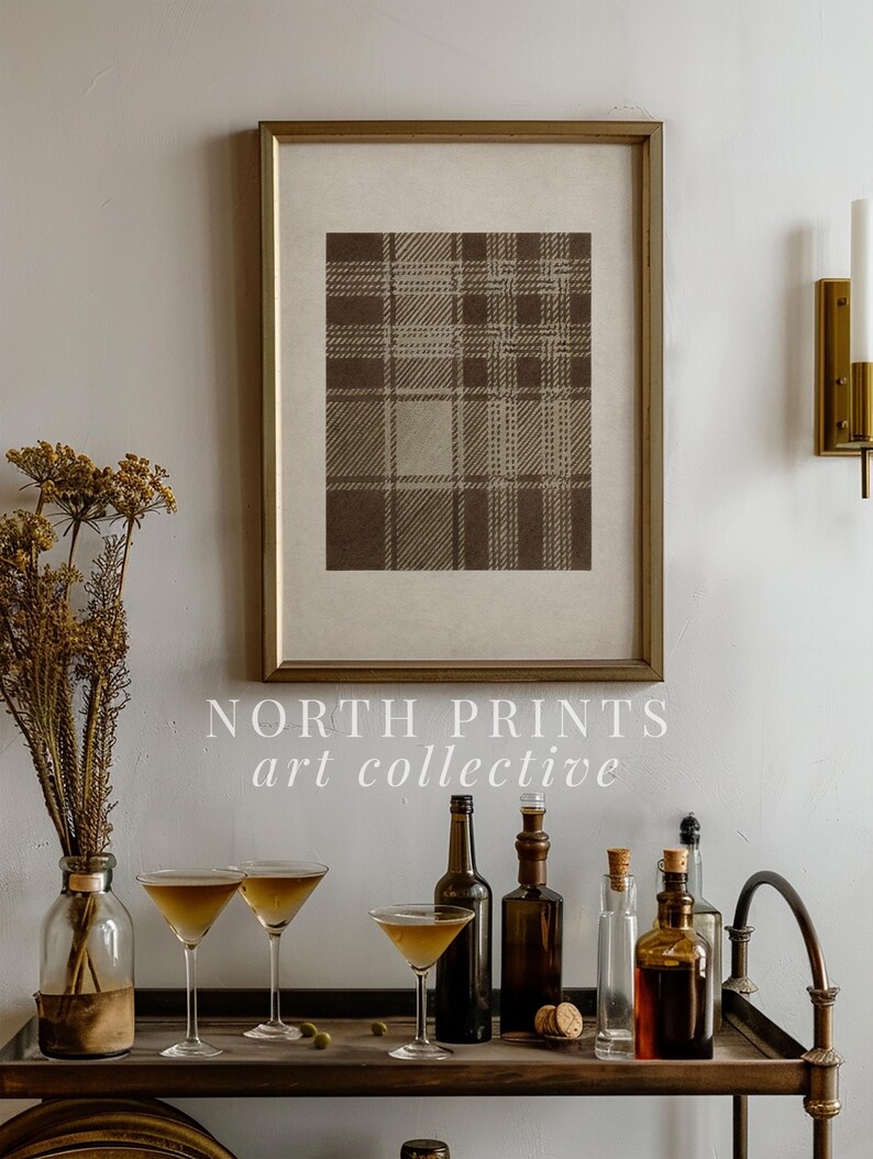 May include: A framed print with a brown plaid pattern hangs above a bar cart. The cart holds martini glasses, bottles, and a vase of dried flowers. The text "NORTH PRINTS art collective" is visible.
