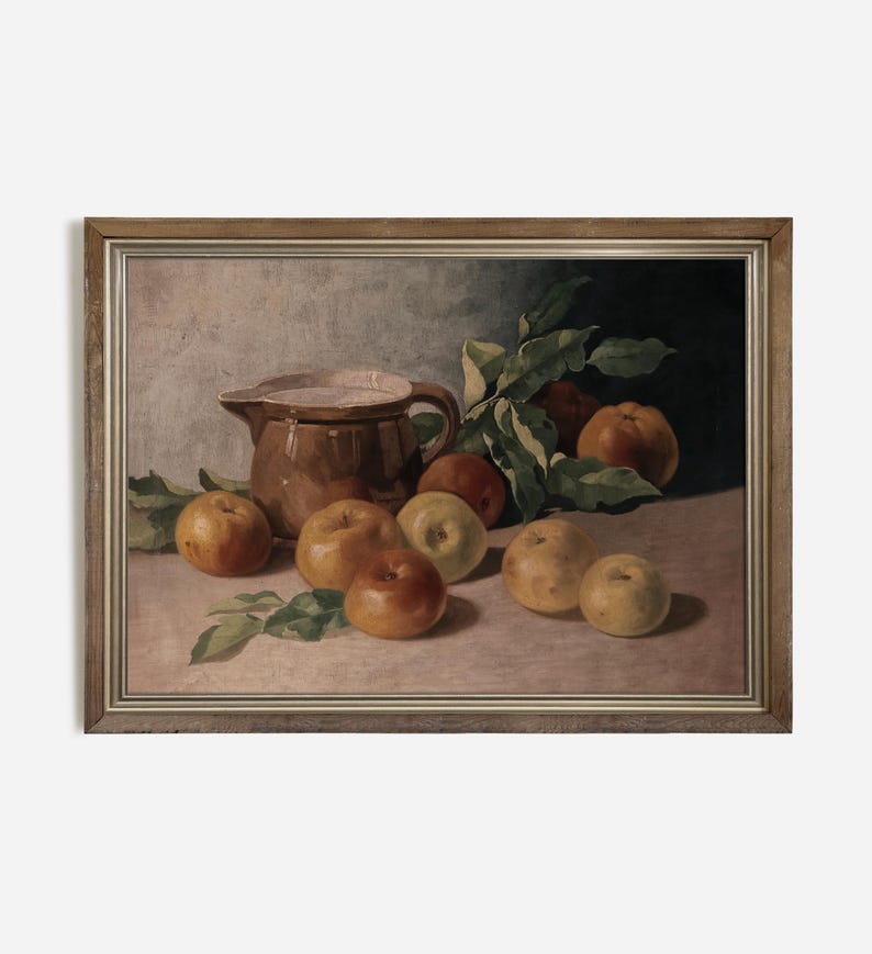 May include: A still life painting of a brown ceramic pitcher and apples in a wooden frame. The pitcher is filled with a white liquid and is surrounded by apples of various shades of red, yellow, and green.