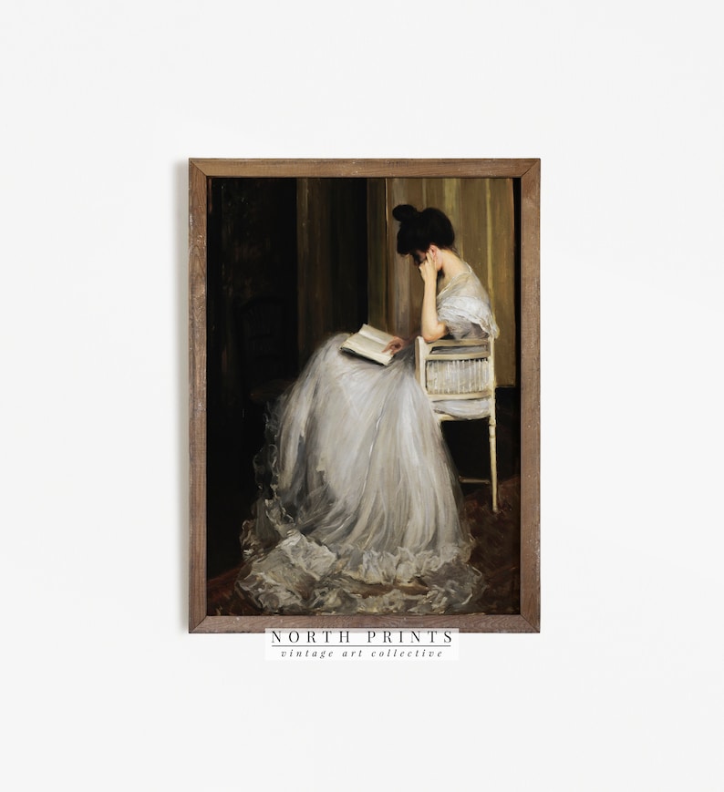 May include: A vintage painting of a woman in a white dress sitting in a chair and reading a book. The painting is framed in a dark wood frame.