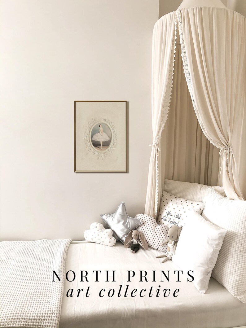 May include: A white canopy bed with a white waffle weave blanket and pillows. The bed has a framed print of a ballerina in a white tutu. The pillows have a variety of patterns, including stars, polka dots, and the text "You are so loved". The text "NORTH PRINTS art collective" is at the bottom of the image.