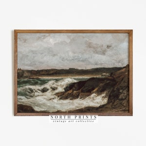 May include: A framed painting of a seascape with crashing waves and a rocky coastline. The sky is cloudy and the water is a deep green. The painting is in a brown wooden frame. The text "NORTH PRINTS vintage art collective" is at the bottom of the image.