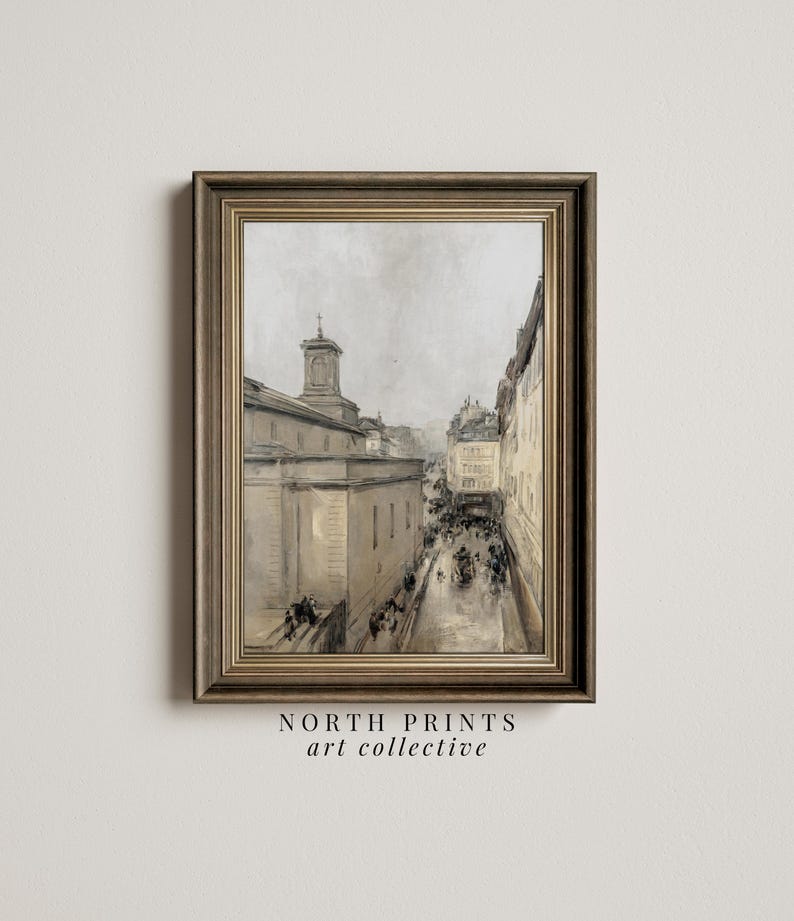 May include: A framed painting depicting a city street scene with a church in the background. The painting is rendered in a muted colour palette of greys and browns. The street is lined with buildings and there are people walking along the street.