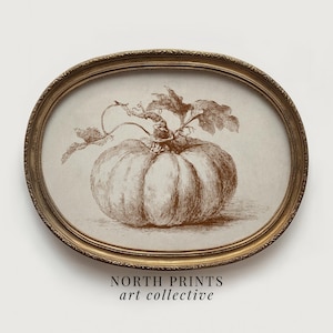 Könnte beinhalten: Sepiafarbene Illustration eines Kürbisses mit Blättern und Ranken in einem ovalen, goldfarbenen Rahmen. Der Rahmen hat einen detaillierten Rand. Der Text "NORTH PRINTS art collective" ist unten zu sehen.
