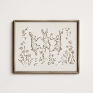 May include: A black and white line drawing of three rabbits hopping in a field of flowers. The rabbits are holding hands and appear to be dancing.