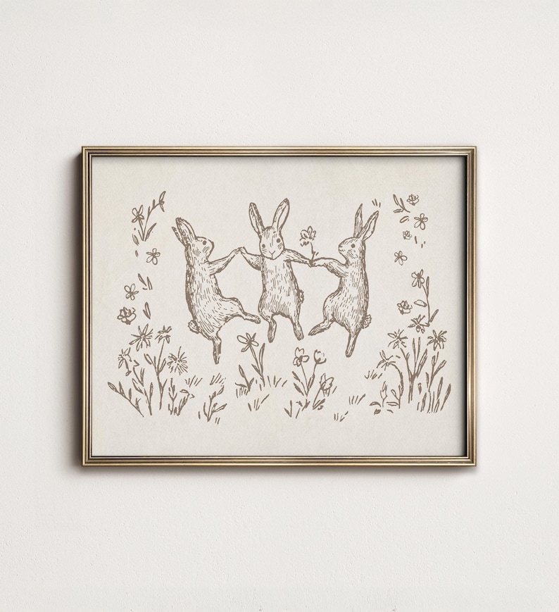 May include: A black and white line drawing of three rabbits hopping in a field of flowers. The rabbits are holding hands and appear to be dancing.