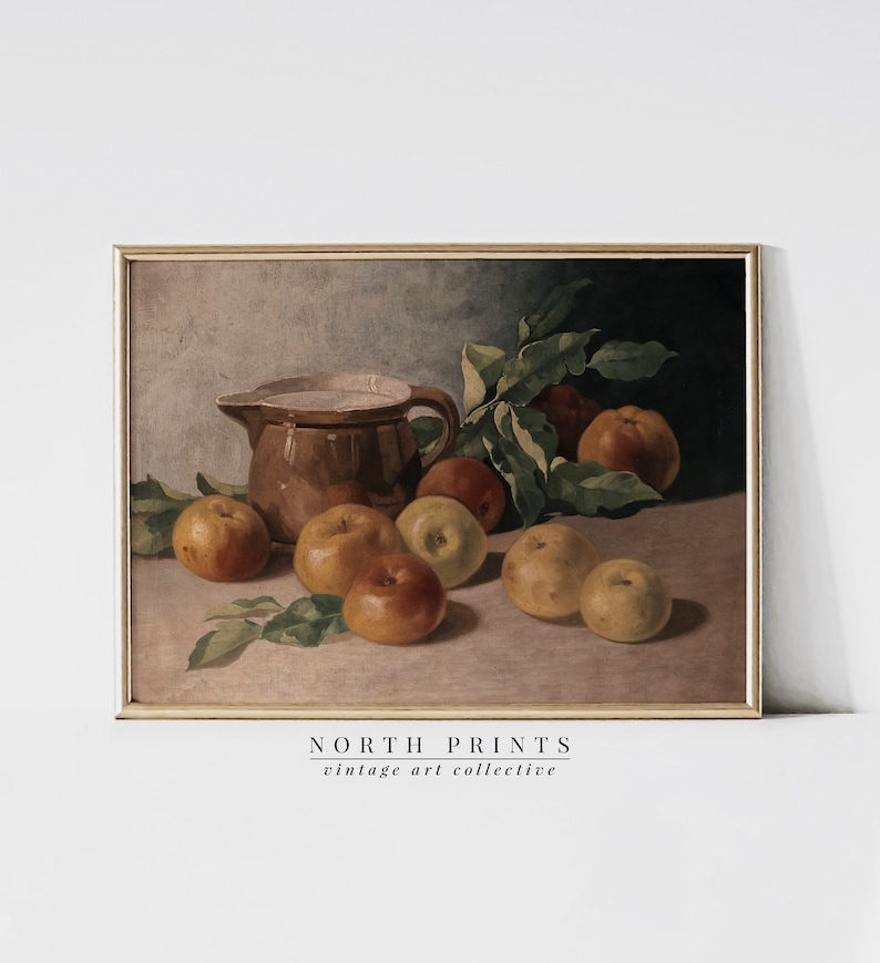 May include: A vintage still life painting of a brown ceramic pitcher and a group of apples on a table. The apples are various shades of red, yellow, and green. The painting is framed in a gold frame.
