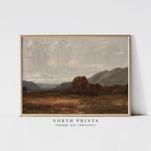 May include: A vintage landscape painting in a brown wooden frame. The painting depicts a rolling hillside with a forest in the foreground and a mountain range in the background. The sky is a light blue with white clouds.
