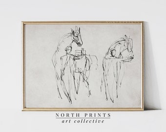 May include: Black and white line drawing of two horses, one with a rider, on a textured background. The drawing is framed in a light wood frame. The text "NORTH PRINTS art collective" is printed below the frame.